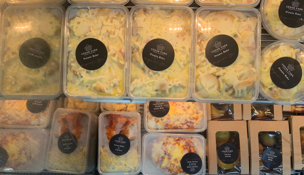Assorted meal prep containers with rice, vegetables, and proteins arranged in rows on a table. — Cedar Park Supermarket In Taranganba, QLD