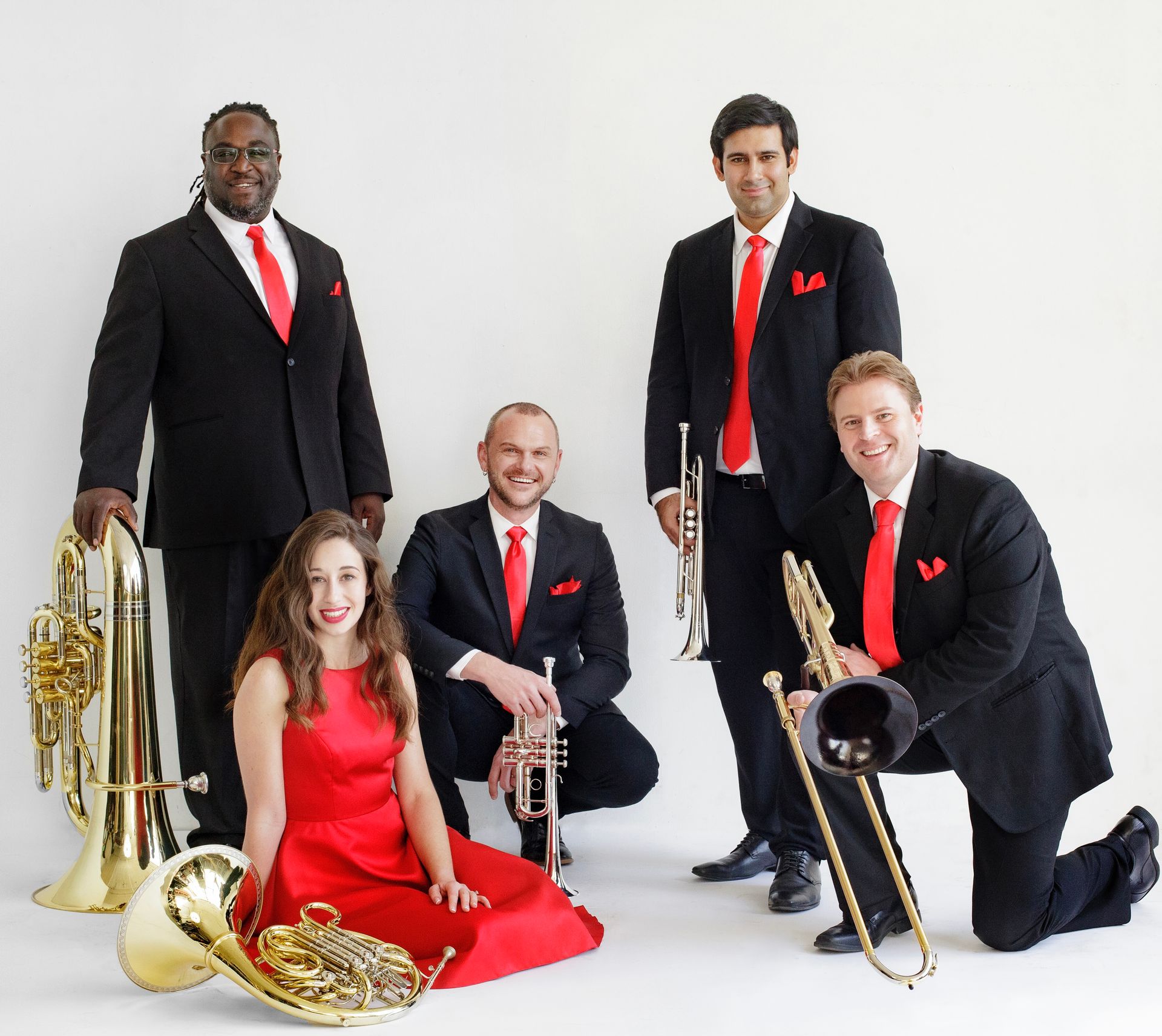 A group of musicians are posing for a picture with their instruments