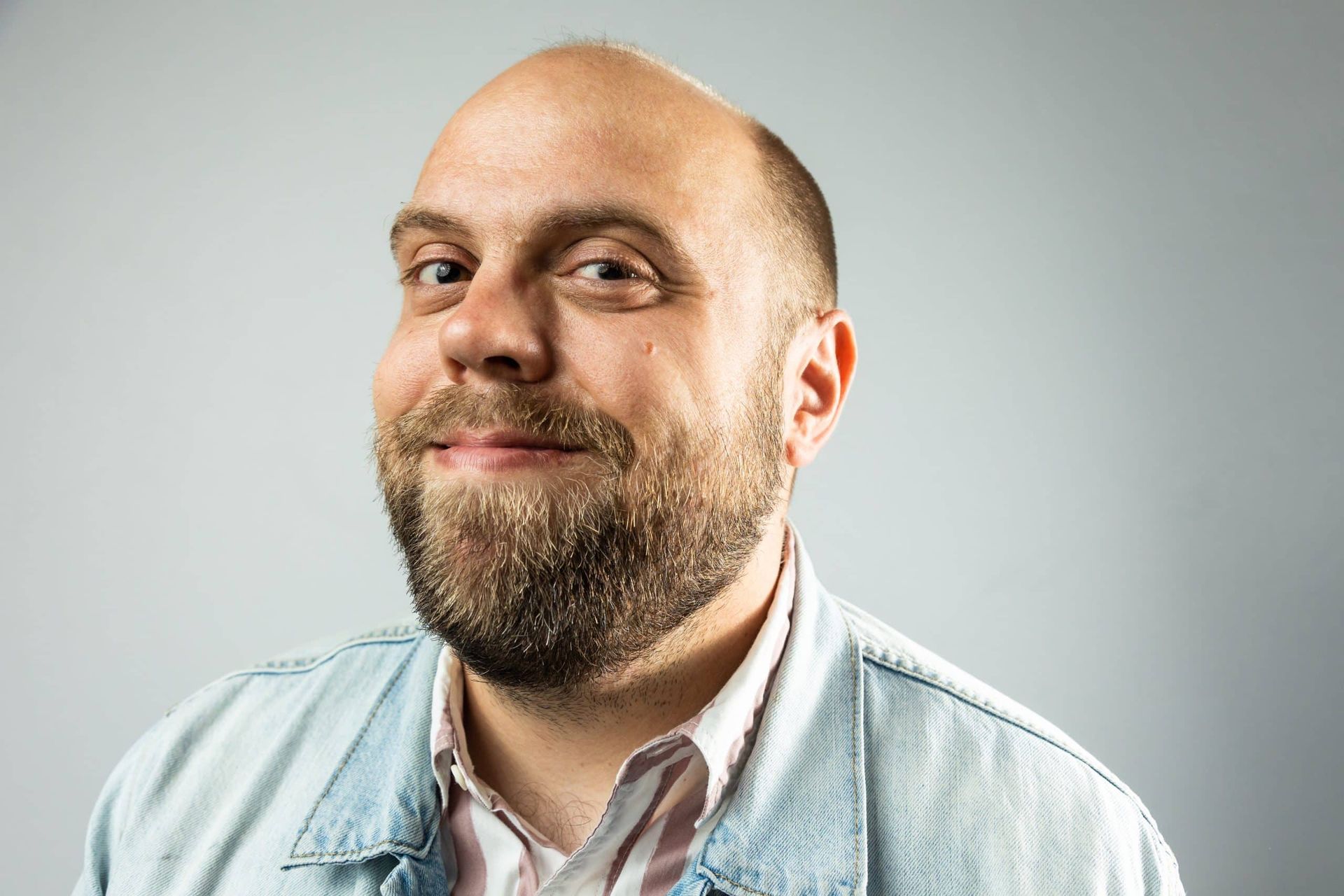 A bald man with a beard is smiling for the camera.