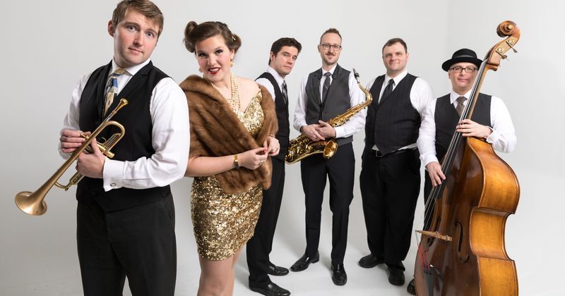 A group of people standing next to each other holding musical instruments.