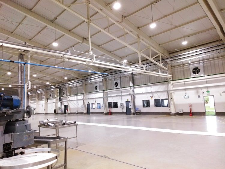 Un gran almacén vacío con un ventilador de techo colgando de él.
