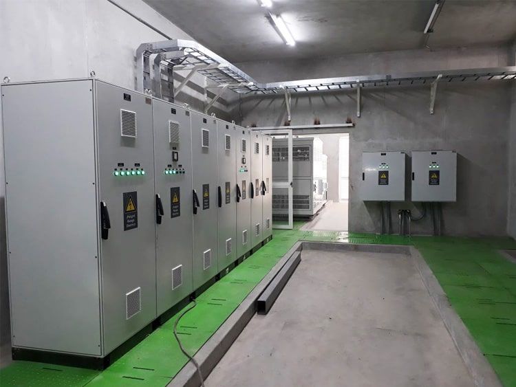 Una habitación con muchas cajas eléctricas y un suelo verde.