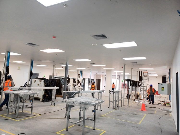 Una sala grande con muchas mesas y gente trabajando en ella.