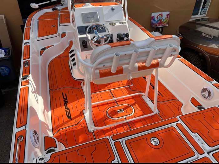 Orange and white fishing boat interior with wooden-textured flooring and seating.