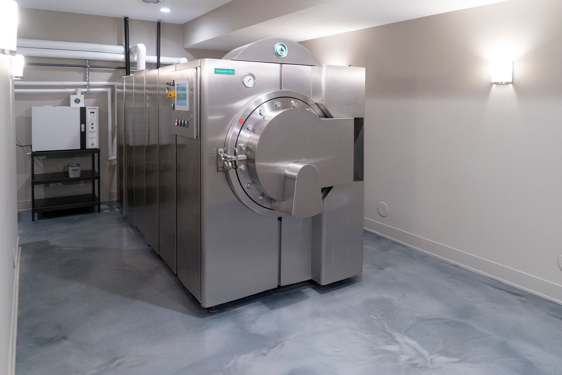 A large stainless steel machine is sitting in a room.