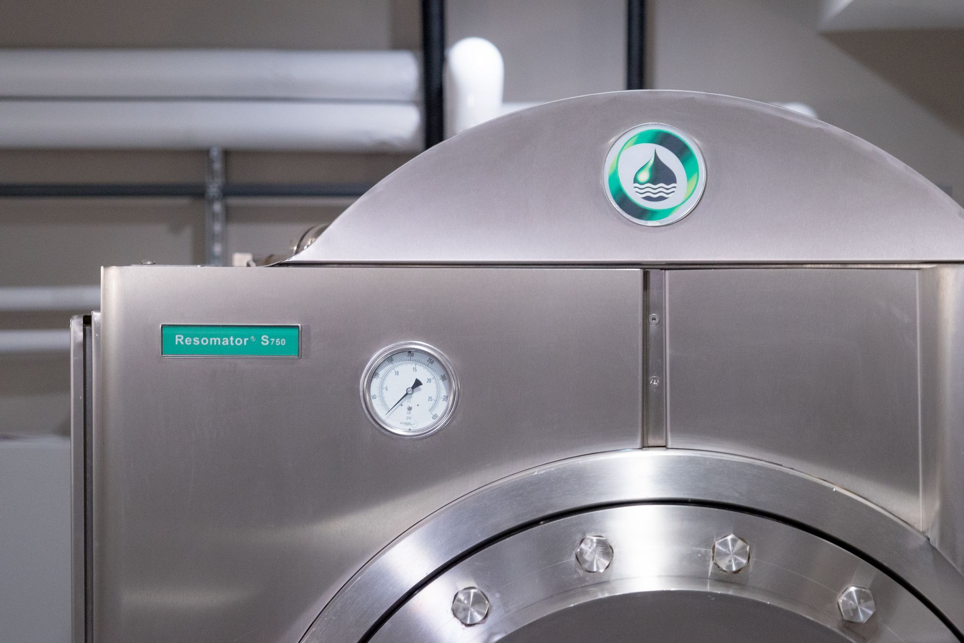 A close up of a stainless steel machine with a clock on it