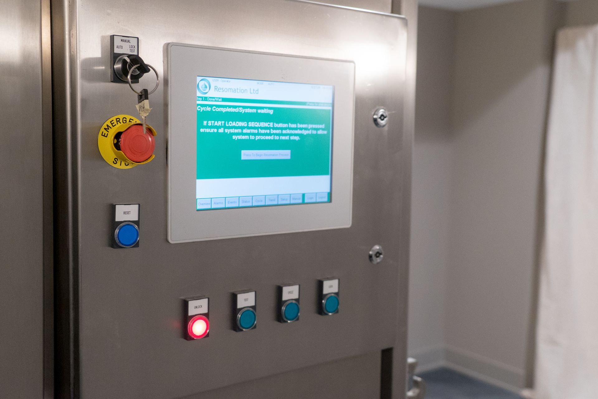 A stainless steel control panel with a monitor and buttons on it.