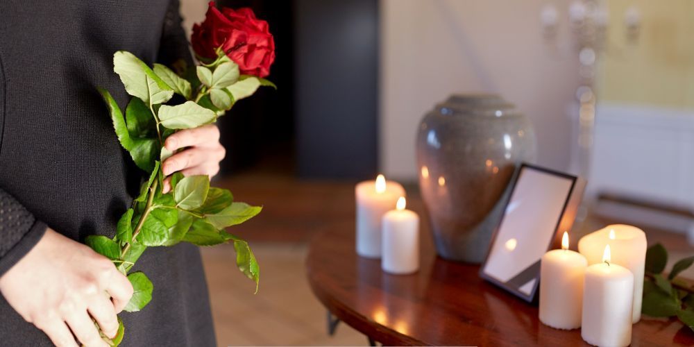 Cremation services in Lakeville, MN with an urn, candles, and roses symbolizing healing