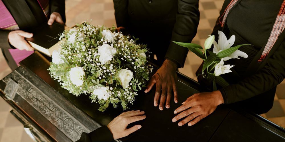 Family gathered around a casket with flowers at a funeral home in Jordan, MN.