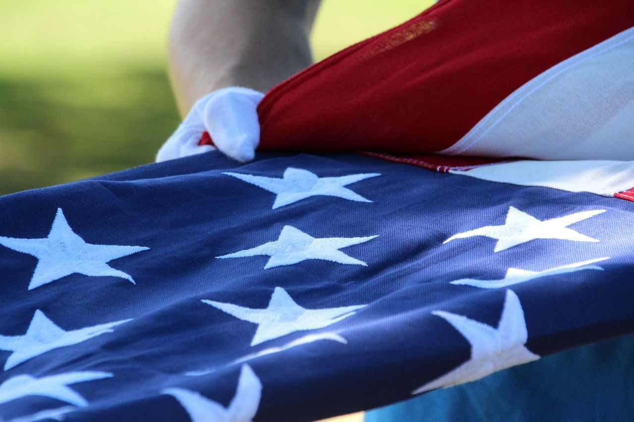 Military funeral with American flag draped on the casket symbolizing patriotism and honor