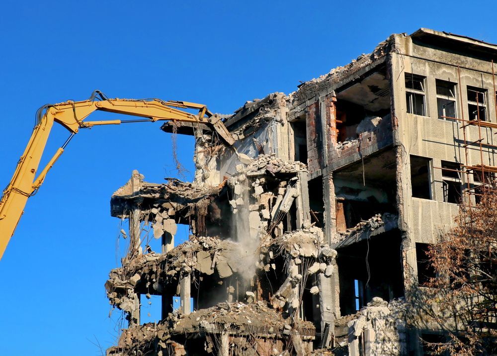 Demolition of A Multi-Story Building with An Excavator — Bigfoot Earthmoving In Lennox Head, NSW