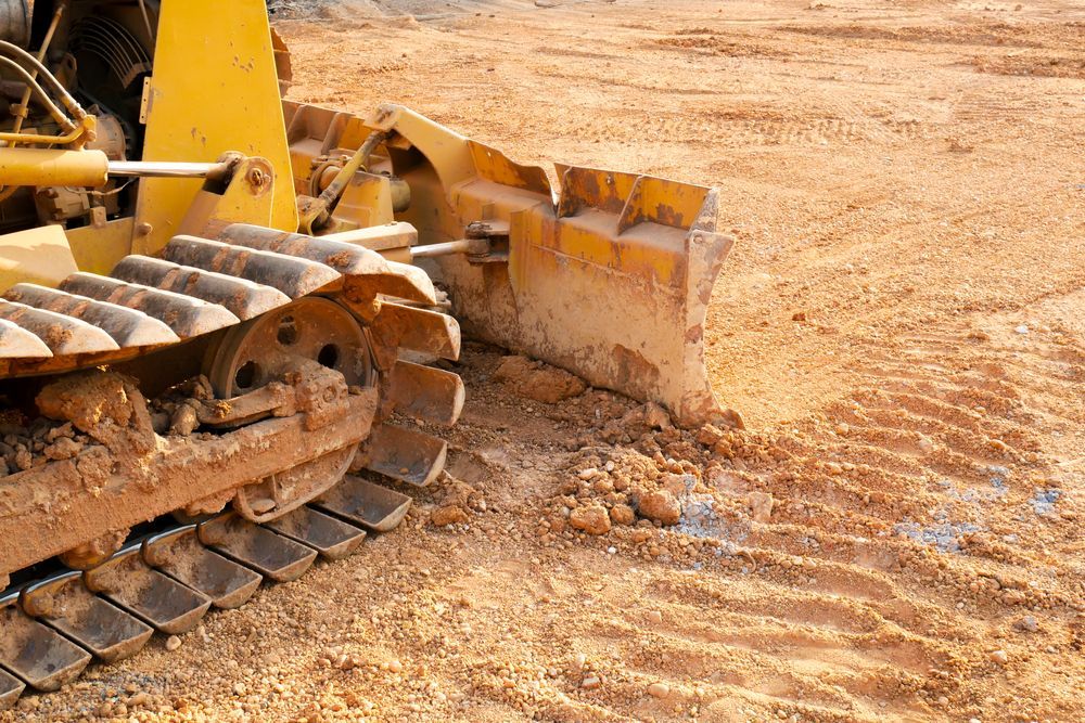 Yellow Bulldozer Blade Pushing Dirt at A Construction Site — Bigfoot Earthmoving In Mullumbimby, NSW