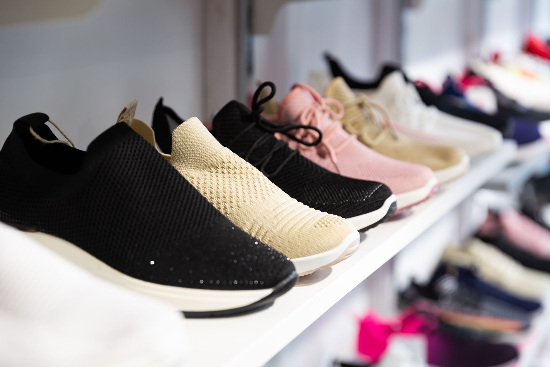Una fila di scarpe è allineata su uno scaffale in un negozio.