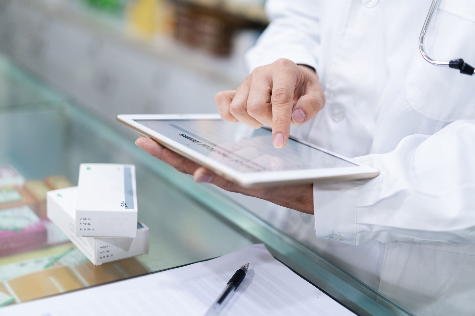 Un medico sta utilizzando un tablet in una farmacia.