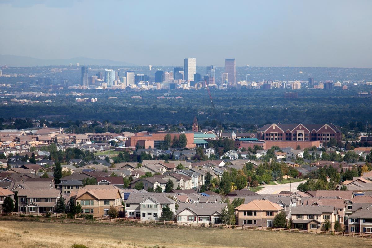 An aerial view of a residential area with a city skyline in the background.