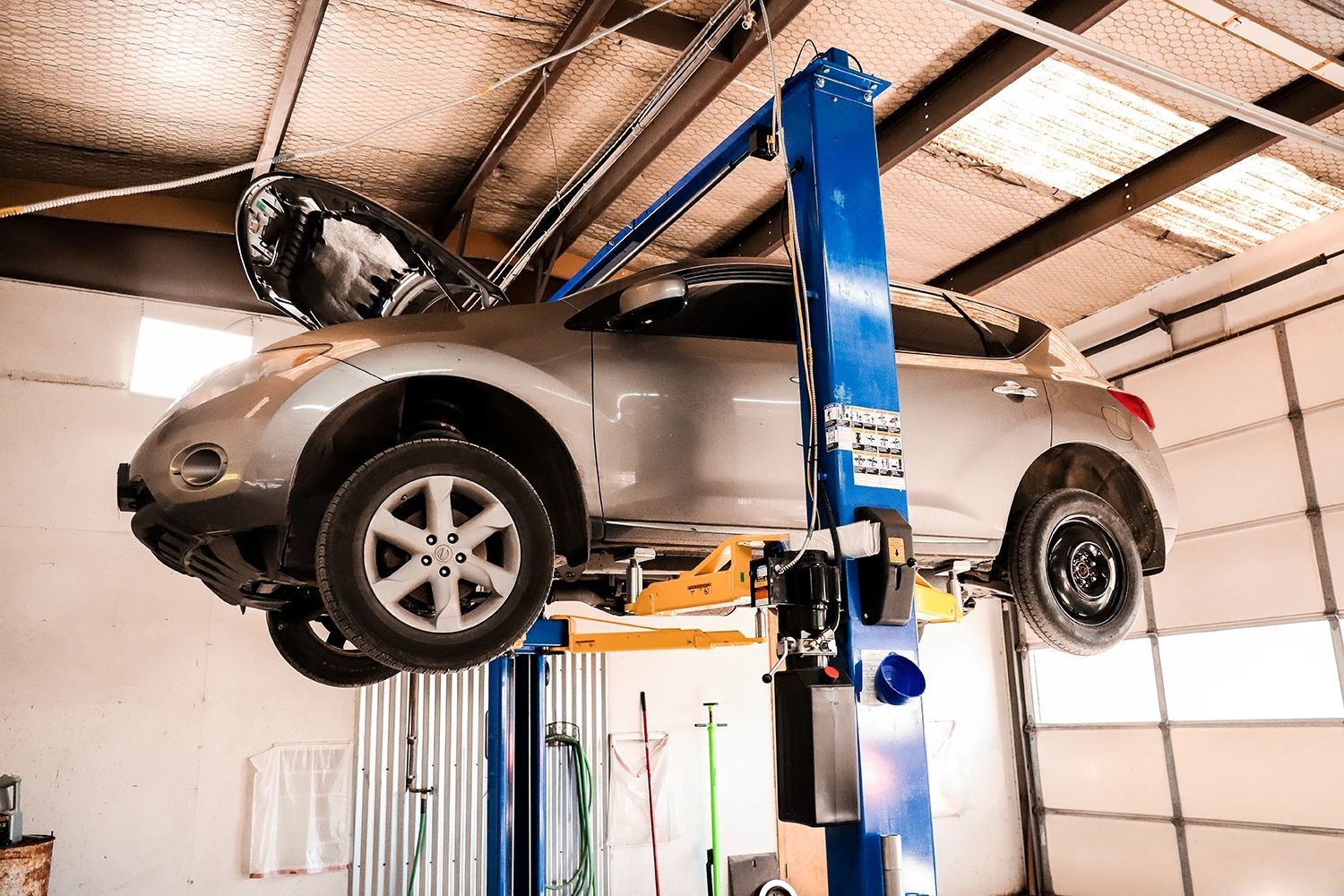 A Silver Car on a Lift in Our Garage in Stillwater, OK | Kaiser Automotive