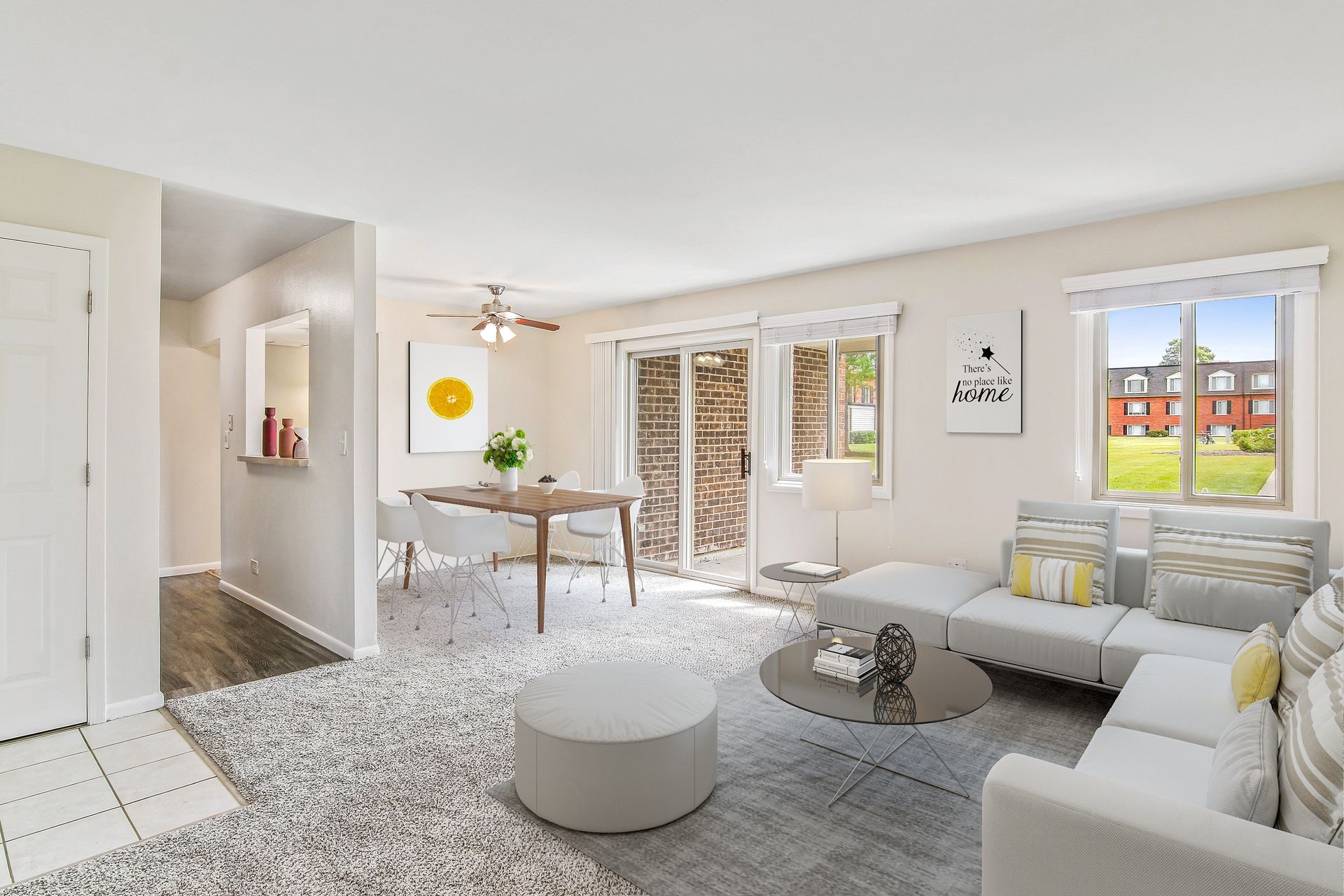 a living room with a couch , table , chairs and sliding glass doors .