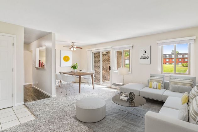 a living room with a couch , table , chairs and sliding glass doors .