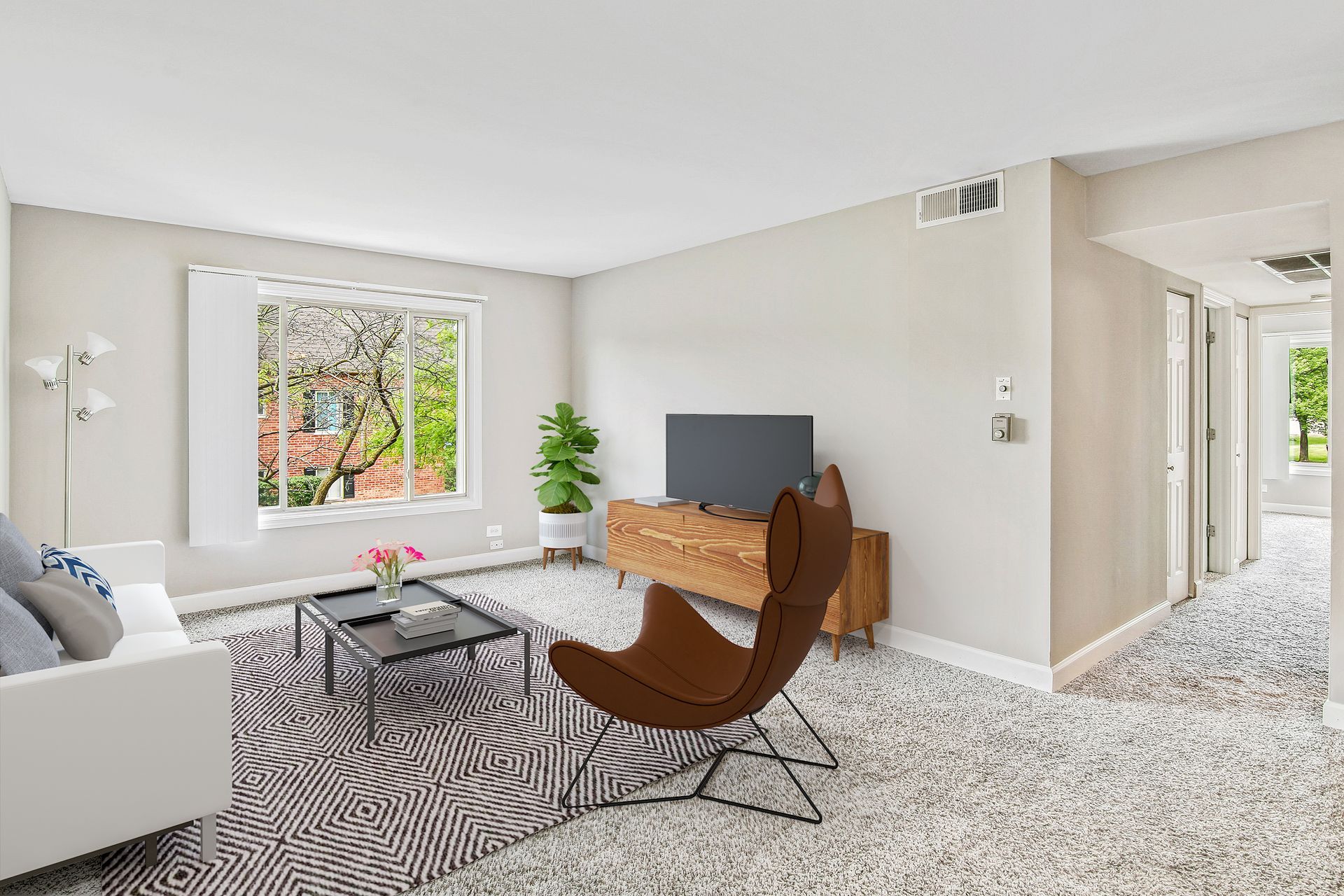 a living room with a couch , chair , table and television .