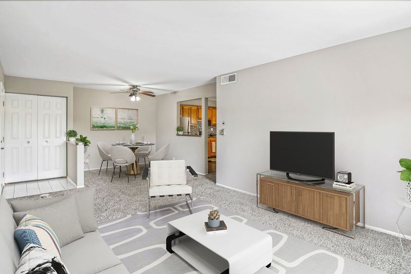 a living room with a couch , coffee table , and television .