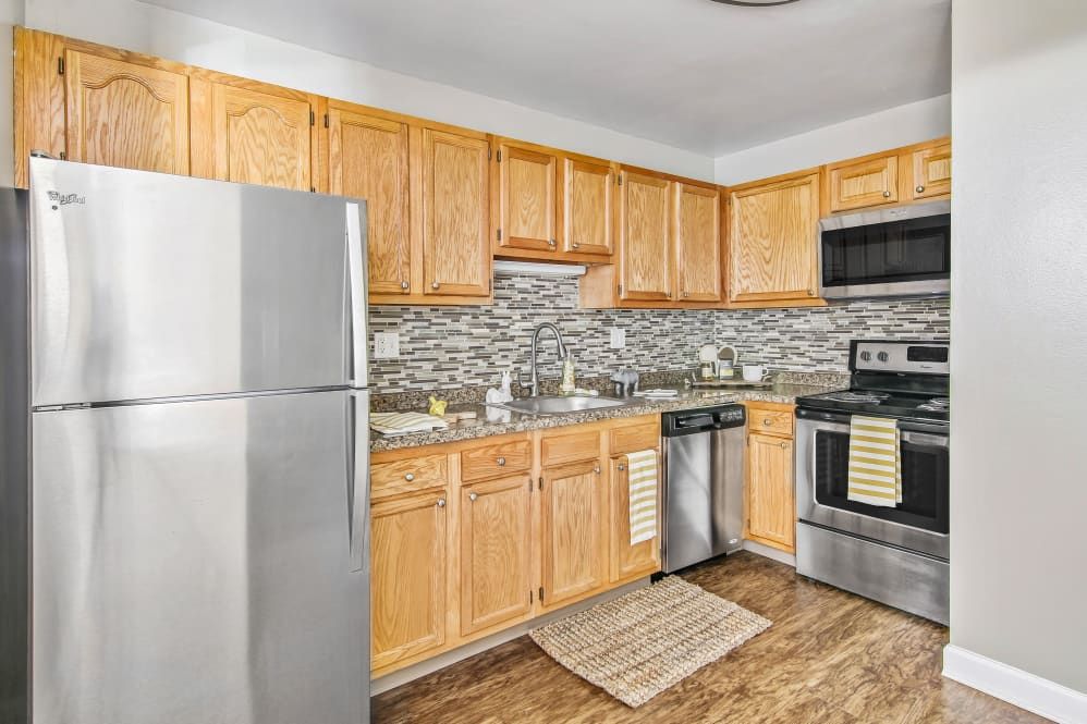 a kitchen with stainless steel appliances and wooden cabinets .