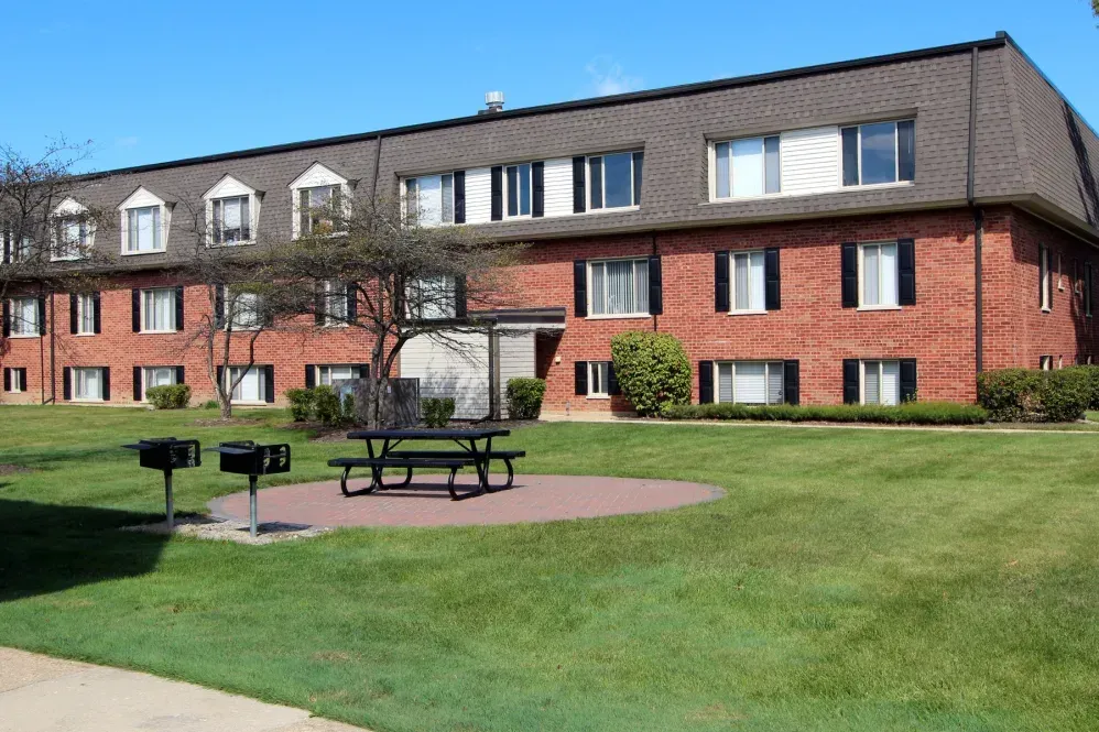a large brick building with a picnic table in front of it