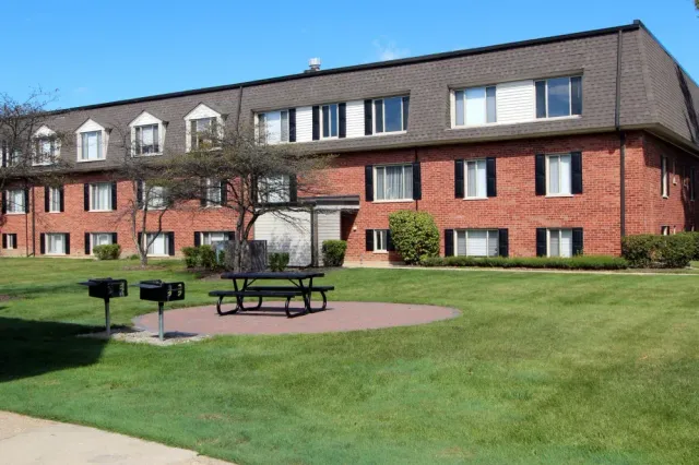 a large brick building with a picnic table in front of it