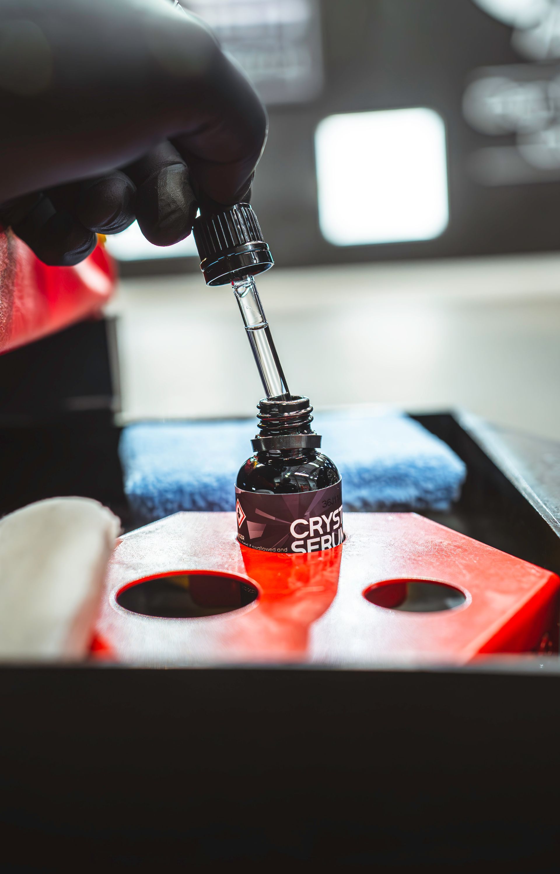 A person is pouring liquid into a bottle with a pipette.