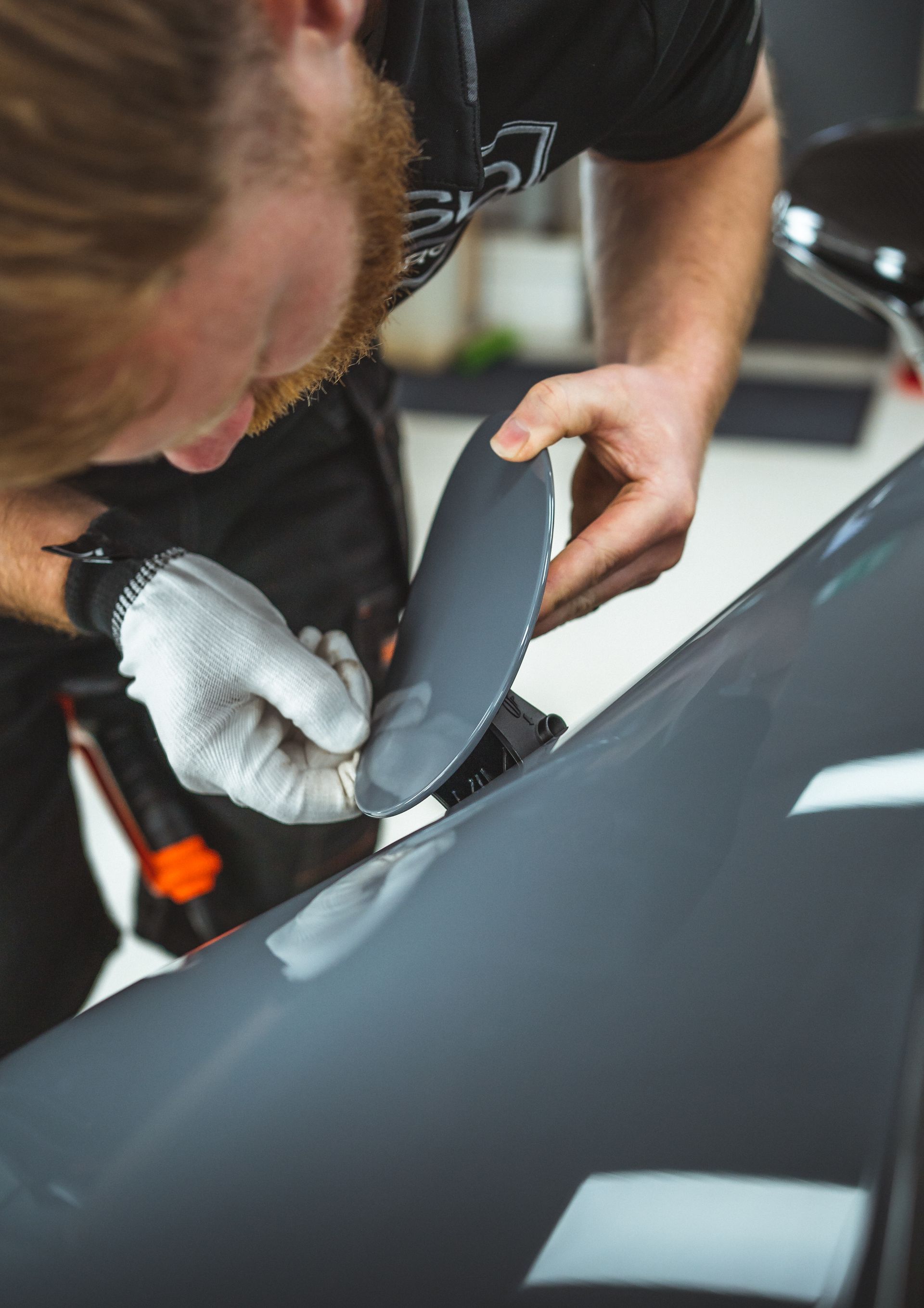 A man is polishing the hood of a car.