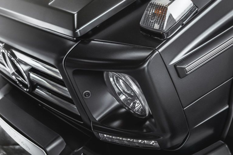 A close up of a black car 's headlight