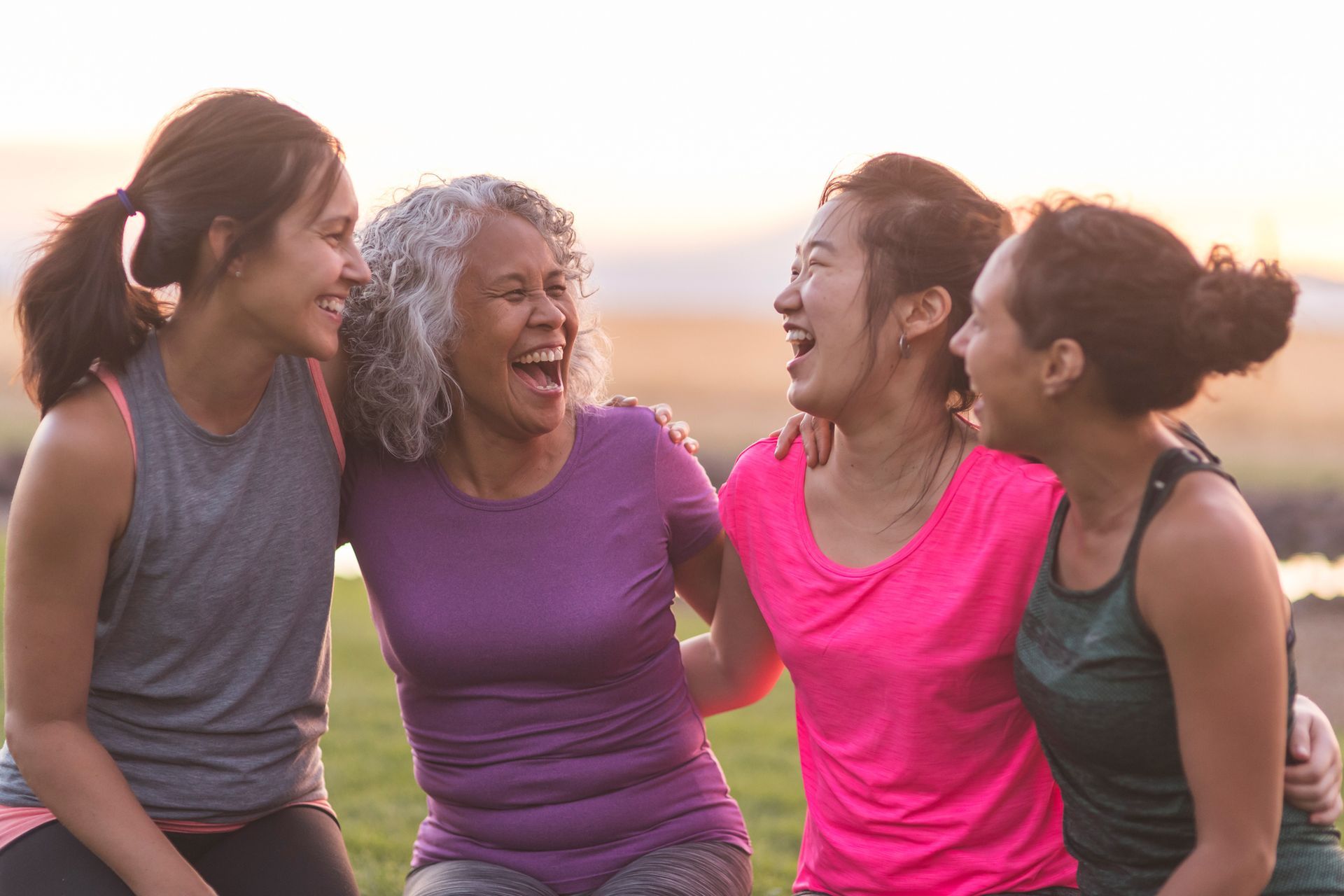 A group of women are sitting next to each other and laughing.