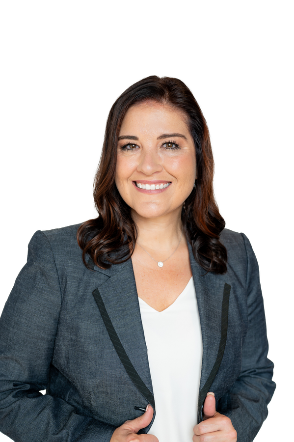 A woman in a gray jacket and white shirt is smiling and giving a thumbs up.