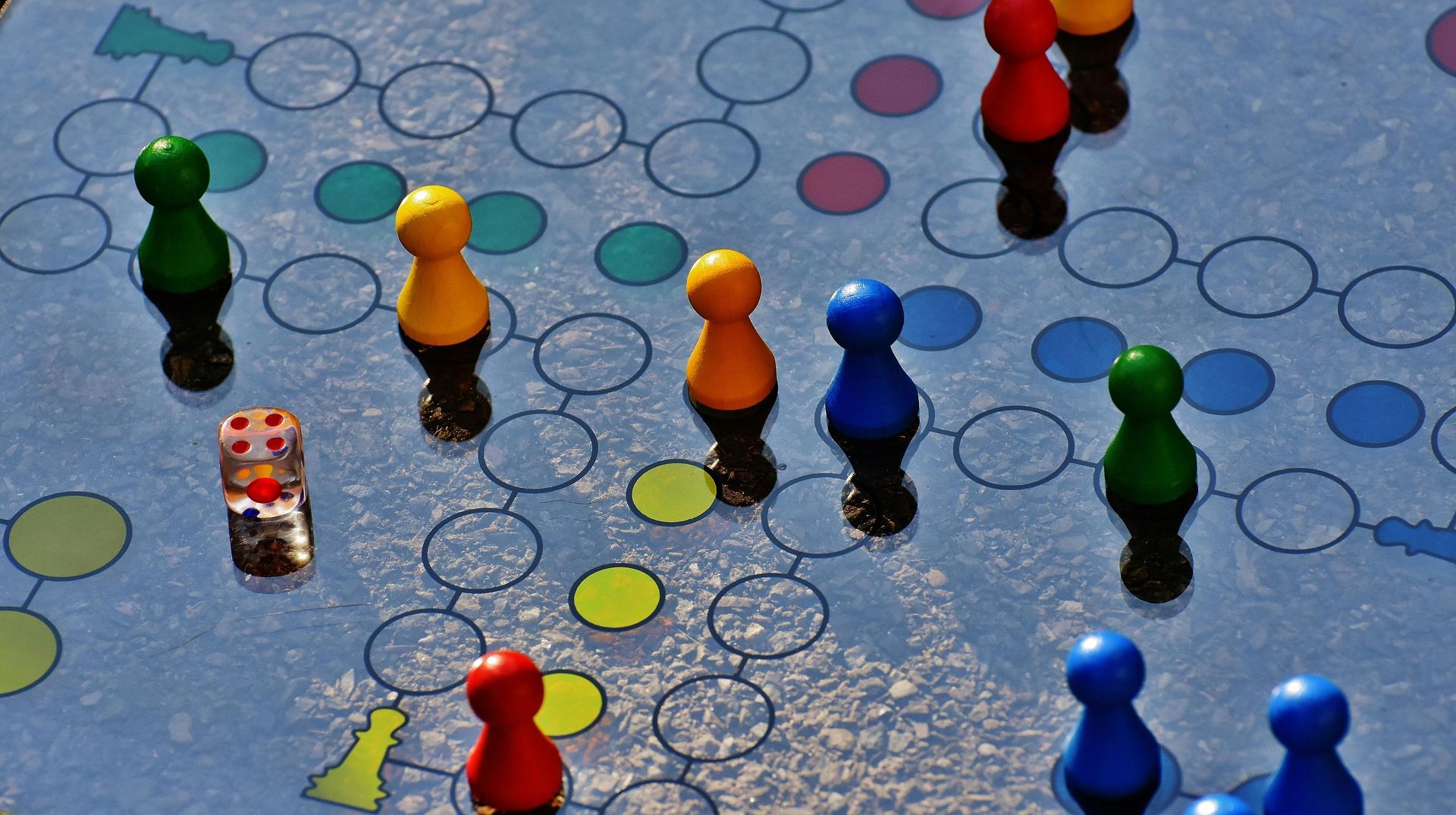 A board game with colored pieces and a dice on it