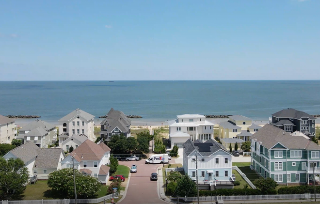 An aerial view of a residential area next to the ocean.