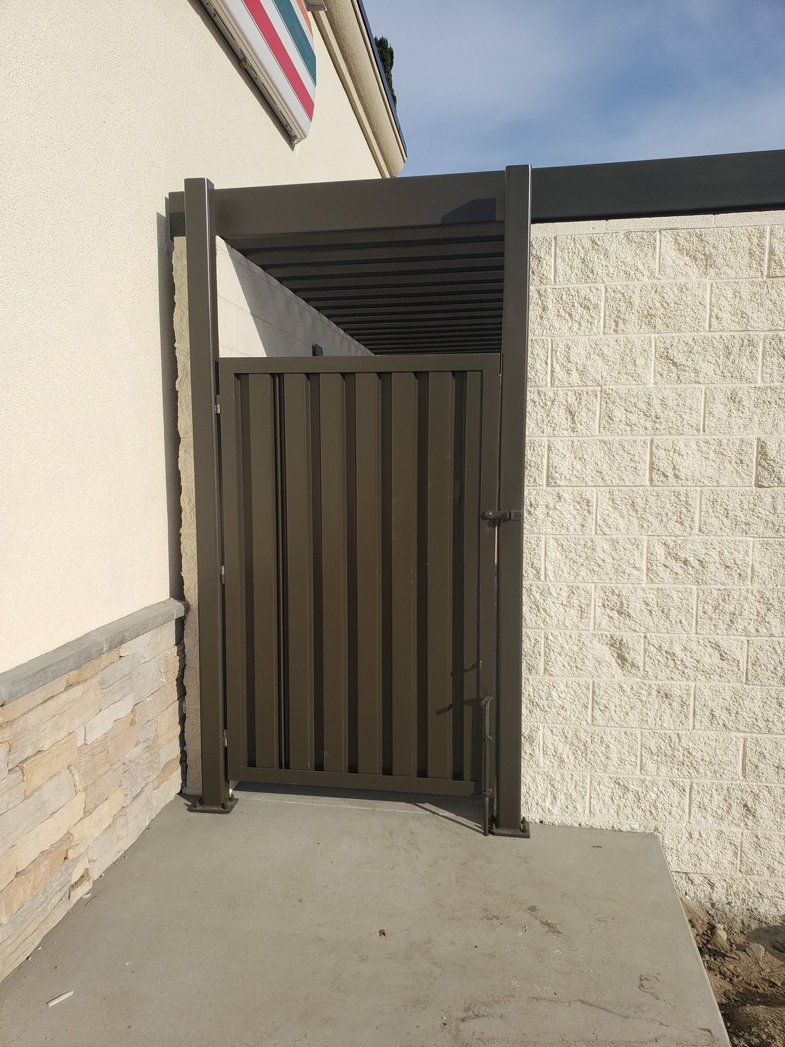 A metal gate is sitting in front of a brick wall.