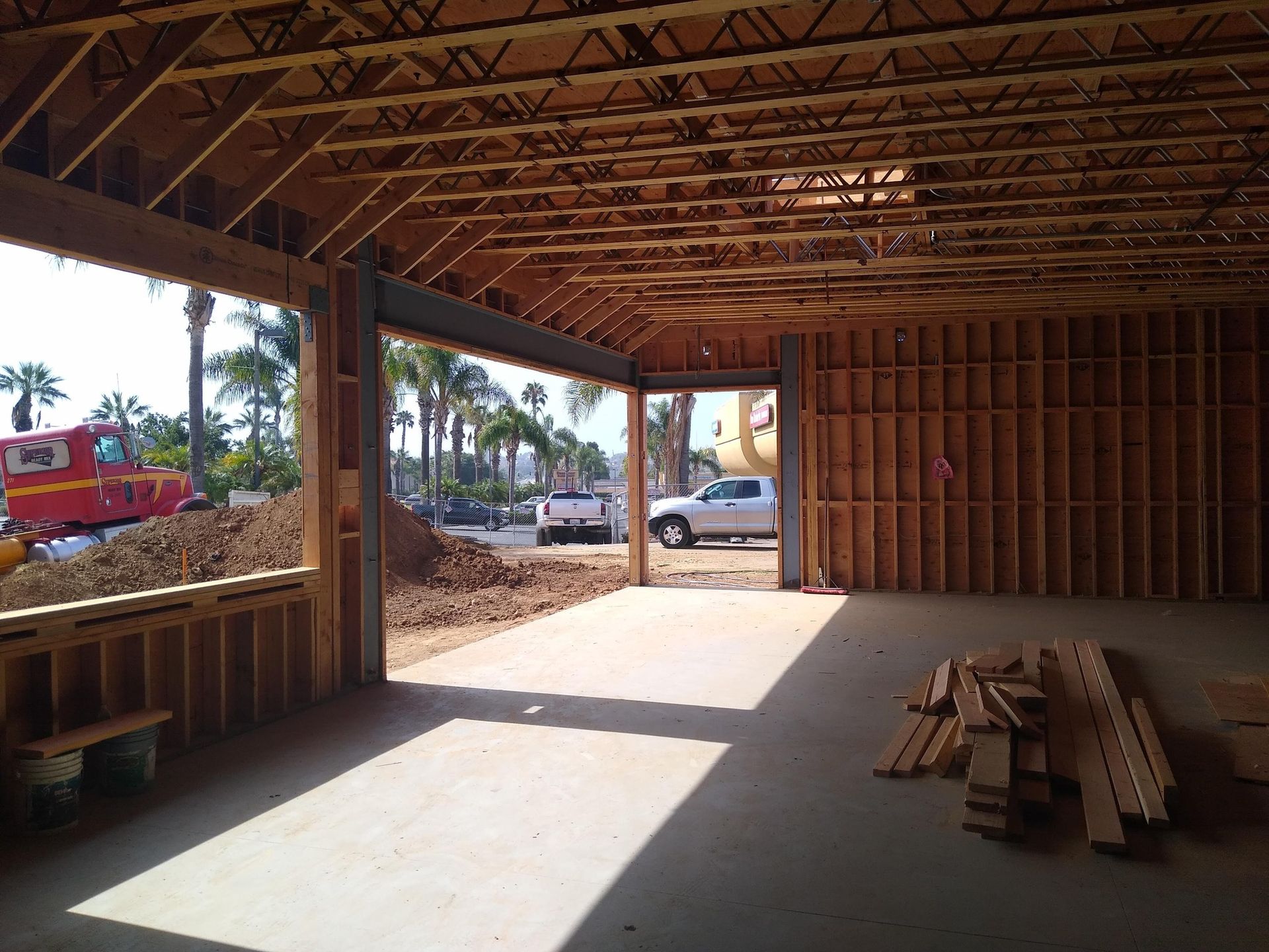 A white truck is parked in a garage under construction
