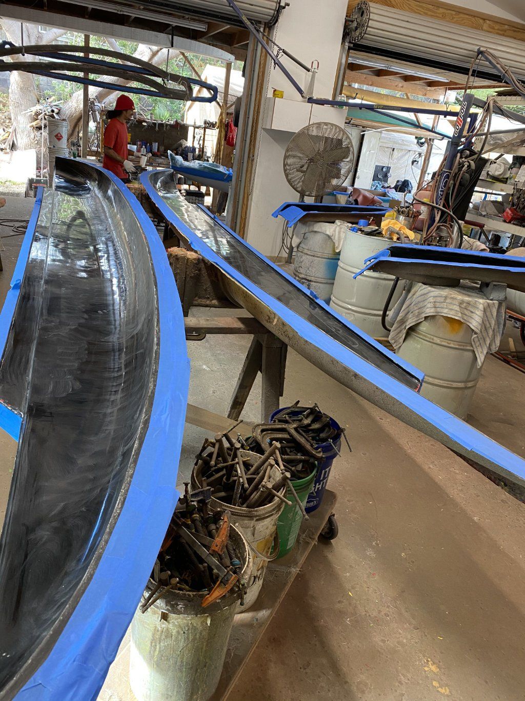 A group of people are working on a boat in a factory.