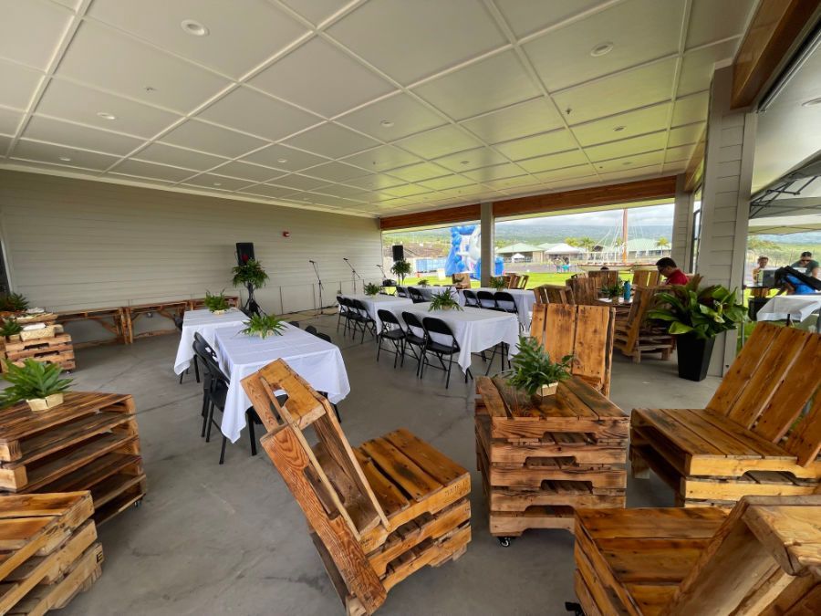 A large room with tables and chairs made out of wooden pallets.