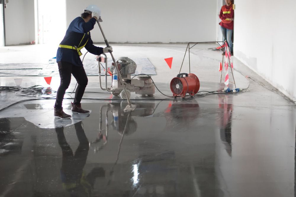 A Man Adding Epoxy To A Concrete Floor — Corbett Brothers Flooring In Central Coast, NSW