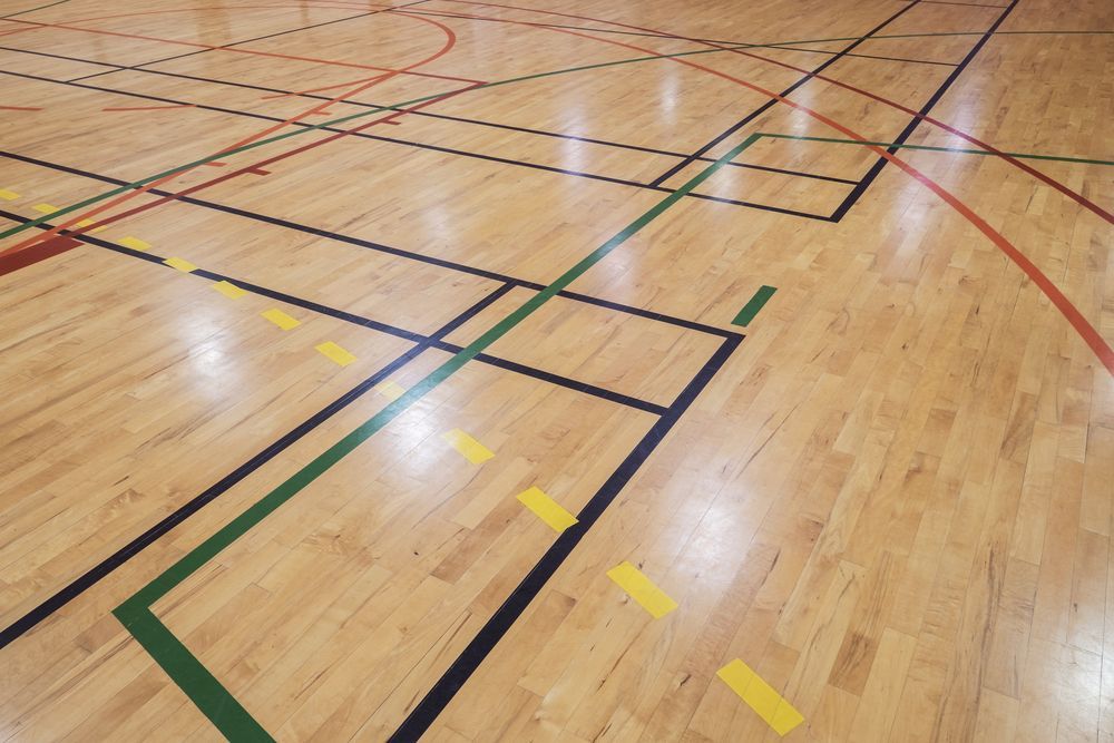 A Basketball Court With A Wooden Floor And Colourful Lines — Corbett Brothers Flooring In Woy Woy, NSW