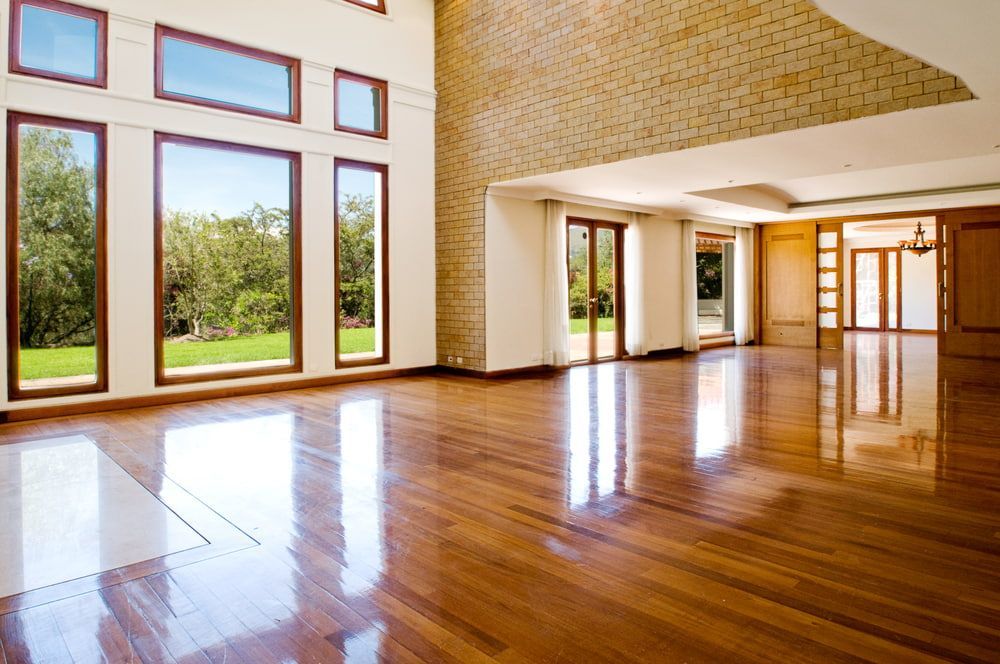 A Large Empty Room With Hardwood Floors — Corbett Brothers Flooring In New Castle, NSW