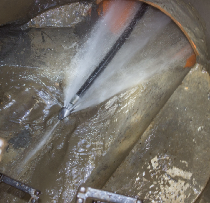 A hose is spraying water into a hole in the ground
