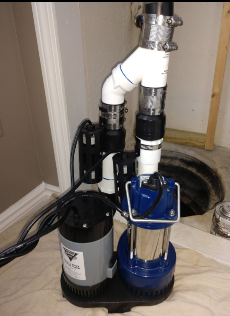 A blue and gray water pump is attached to a white pipe