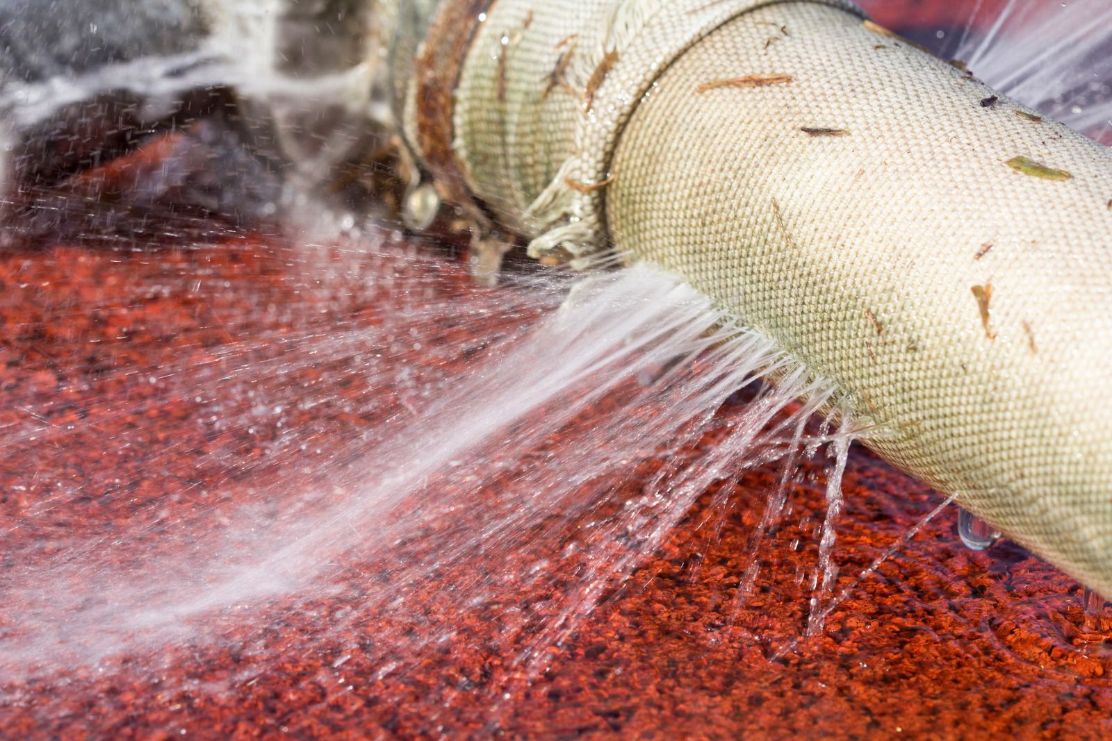 A pipe is leaking water on a red carpet.