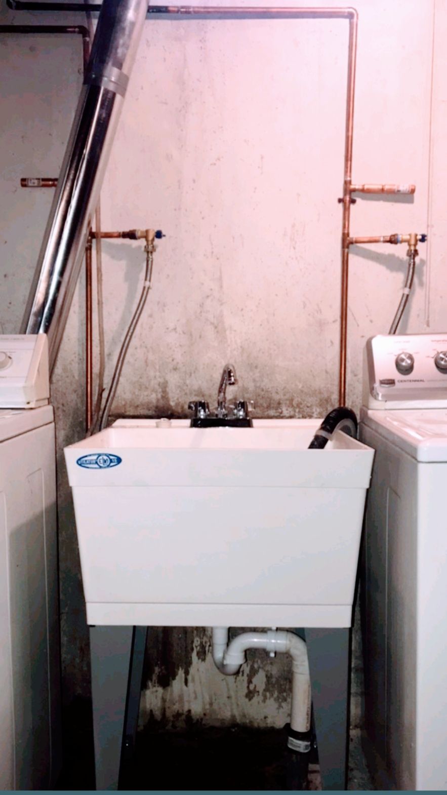 A laundry room with a sink and a washer and dryer.