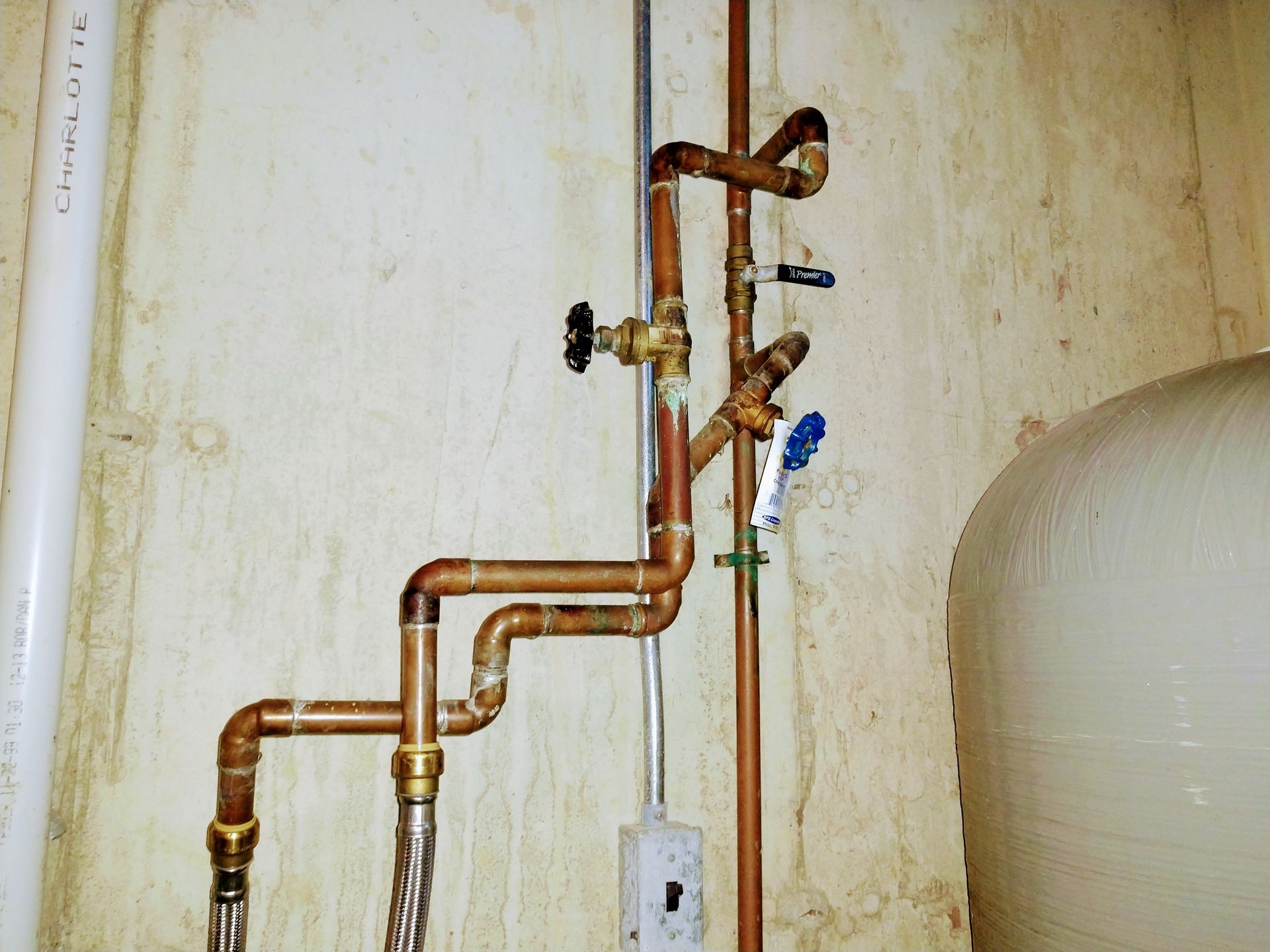 Copper pipes are connected to a white pipe with the word climb on it