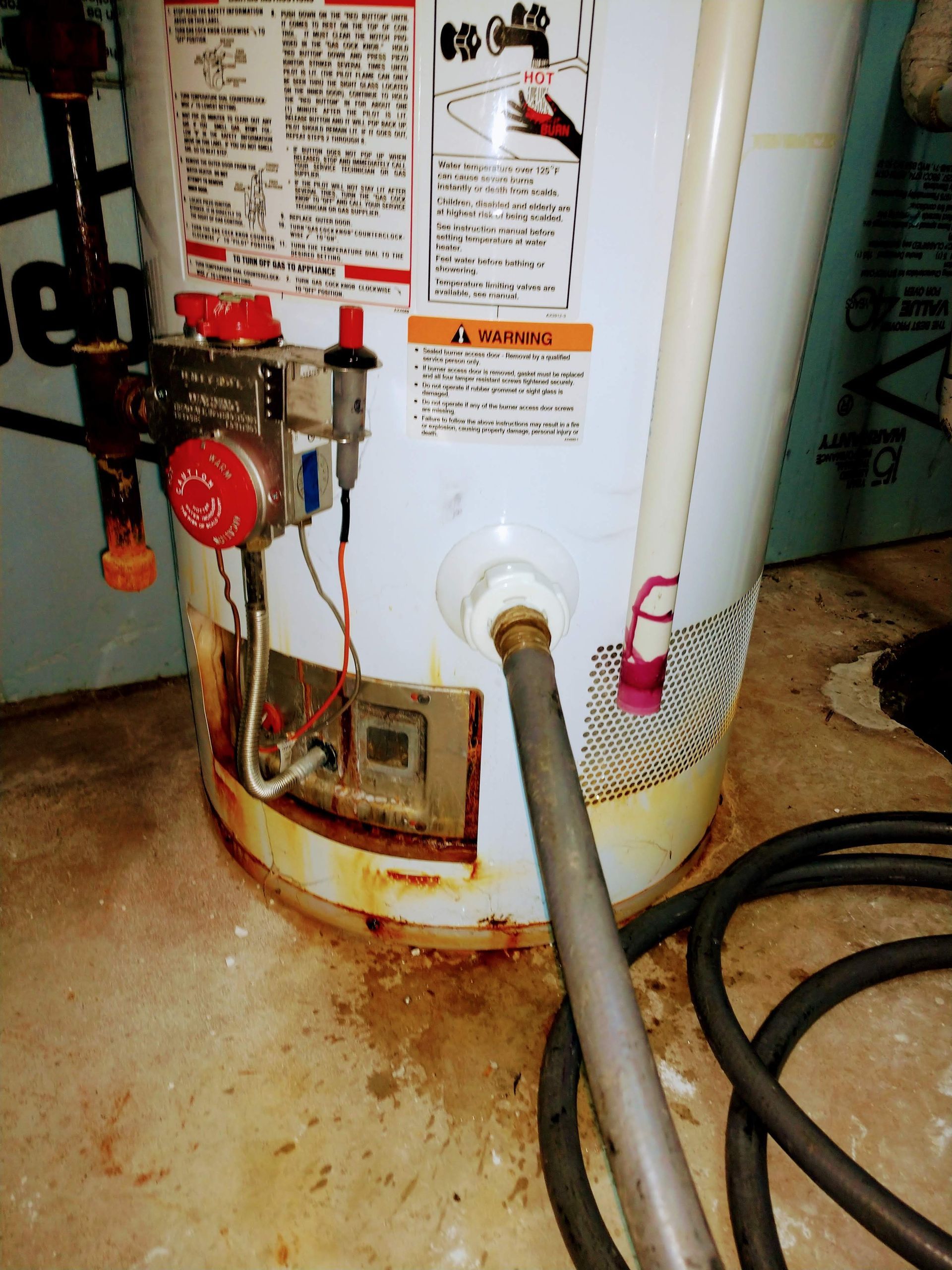 A water heater with a hose attached to it