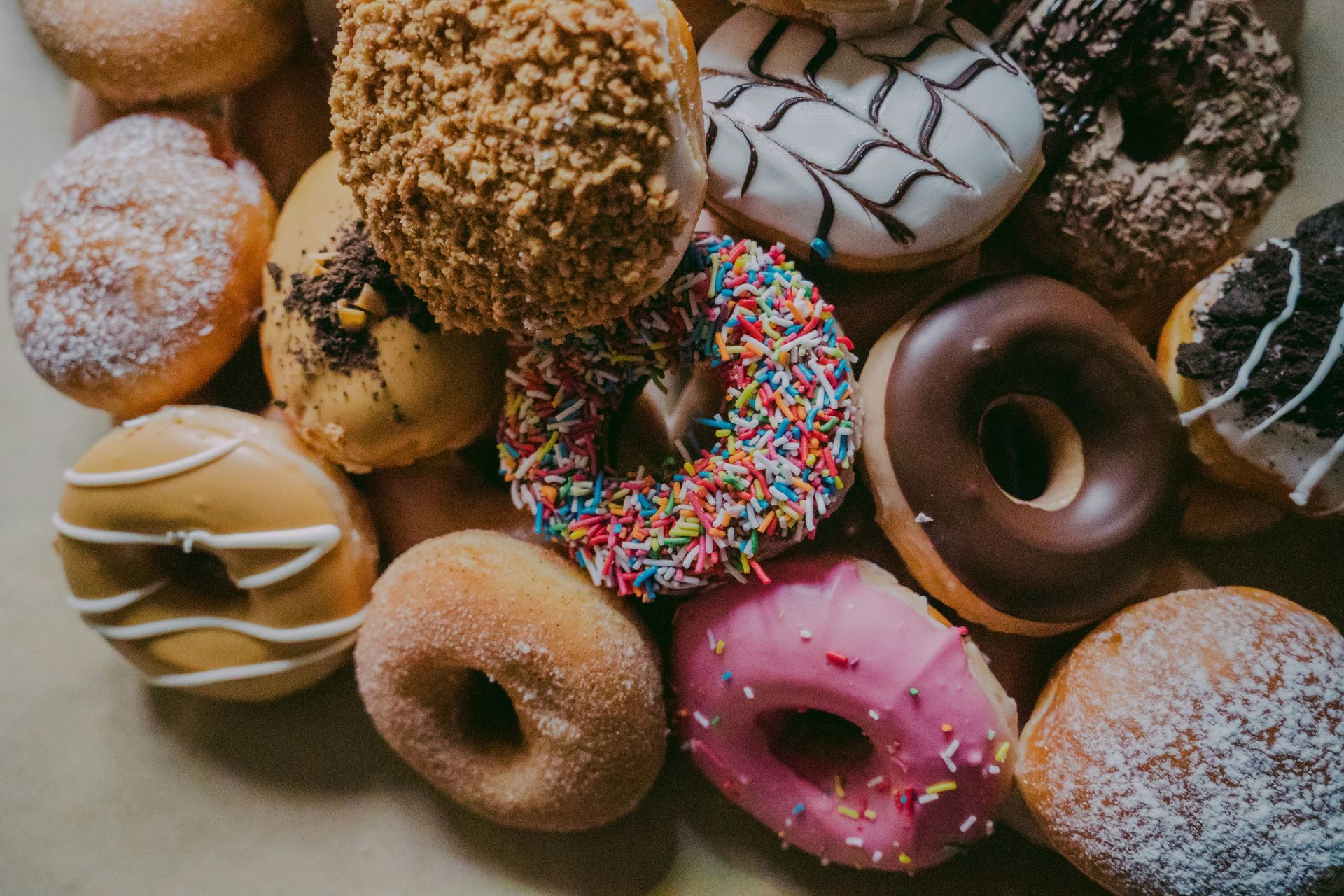 Bunte Auswahl verschiedener Donuts und gefüllter Krapfen in der Draufsicht – als Metapher für Though