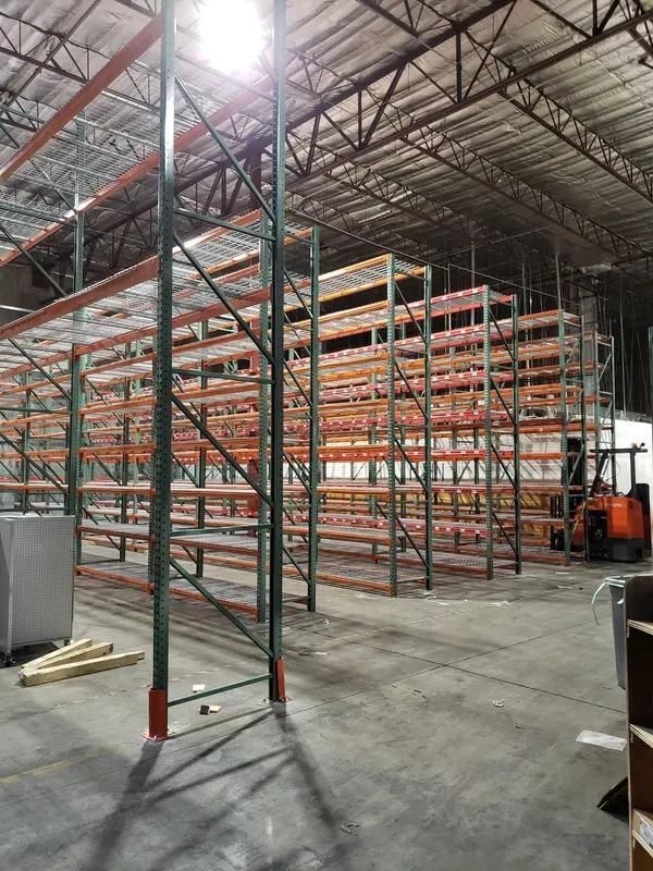 A large warehouse filled with lots of shelves and a forklift.