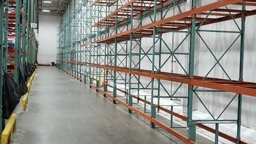 A warehouse filled with lots of shelves and a concrete floor.